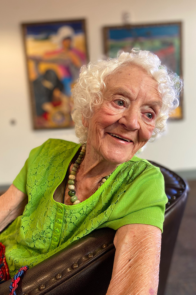 Pilar smiles over her shoulder, wearing a bright green top