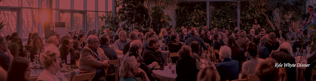 Attendees of Kyle Whyte's dinner reception. There is a maroon filter covering the whole image.